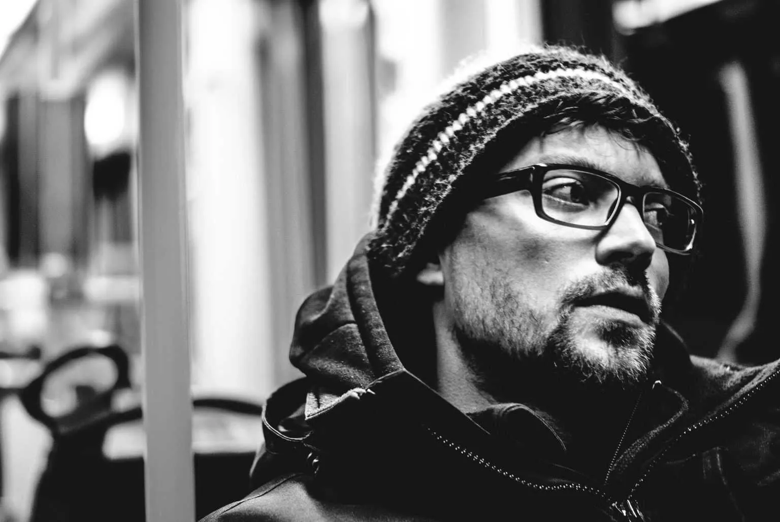 Young man in hooded jacket sitting in a train