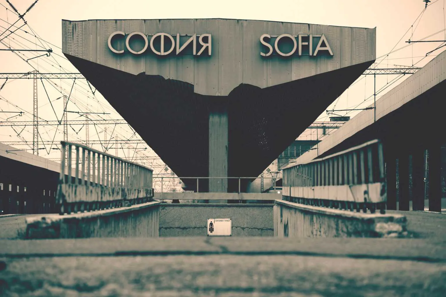 Front view of Sofia Central Railway Station entrance with large Sofia sign in Cyrillic and Latin letters above the structure.