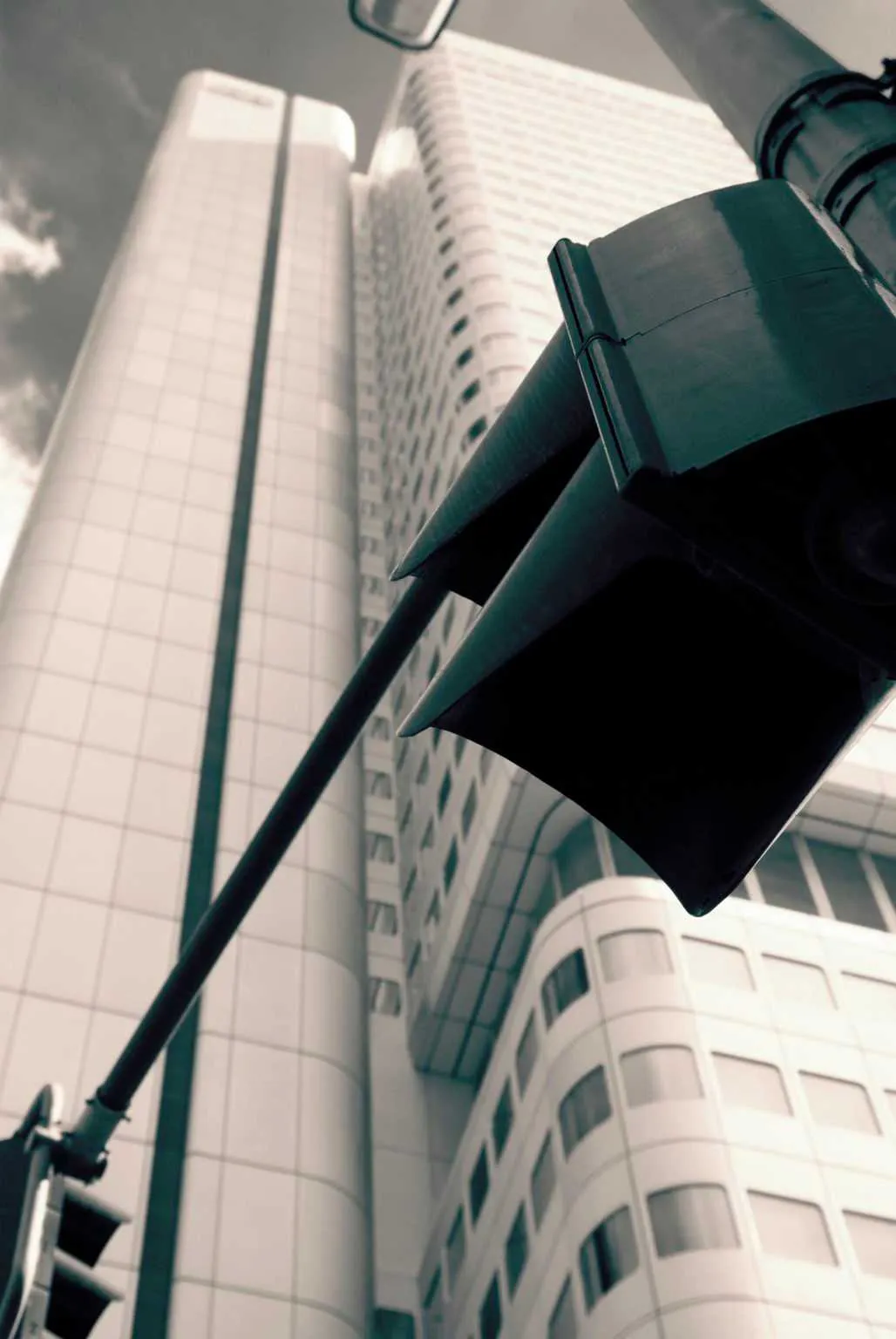 Low angle view of a traffic light with modern high-rise buildings in the background.